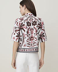 A woman in a patterned shirt stands against a plain background. carousel Product Image 2