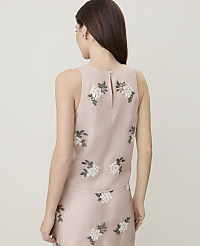 A woman in a pink floral top and skirt stands against a plain, light background. carousel Product Image 2