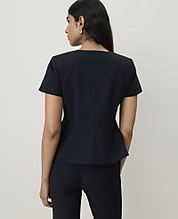 A woman in a navy peplum top and pants stands against a plain white background. carousel Product Image 2