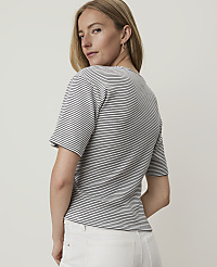 A woman in a striped shirt and white pants stands against a plain, light-colored background. carousel Product Image 2