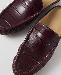A pair of burgundy leather loafers with a penny strap detail are laid out on a white background. carousel Product Image 2