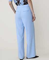 A person wearing light blue wide-leg trousers and a patterned top stands against a plain, light-colored background. carousel Product Image 3