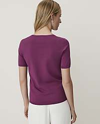 A woman in a purple short-sleeved sweater and white pants stands against a plain white background. carousel Product Image 2