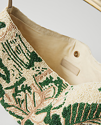 A beaded bag with a floral pattern in green and pink is shown against a blurred background. carousel Product Image 2