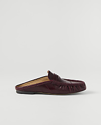 A burgundy patent leather loafer mule rests on a plain white background. carousel Product Image 1