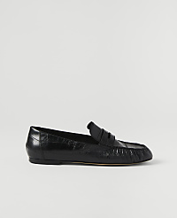 A black leather loafer rests on a plain white background. carousel Product Image 2
