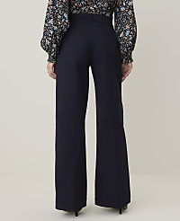 A person wearing a floral blouse and dark wide-leg pants stands against a plain, light-colored background. carousel Product Image 3