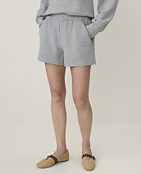 A person stands in grey sweat shorts and espadrille flats against a plain, light background. carousel Product Image 2
