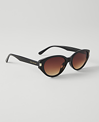 Black cat-eye sunglasses with gradient brown lenses rest on a plain white background. carousel Product Image 2