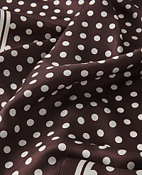 A close-up of a brown polka dot fabric with white dots fills the foreground, while the background is a continuation of the same patterned material. carousel Product Image 2