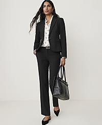 A woman in a black suit and patterned blouse stands with a black tote bag against a plain white background. carousel Product Image 5