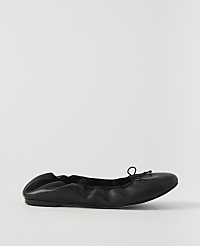 A black leather ballet flat with a drawstring bow rests on a plain white background. carousel Product Image 1