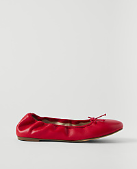 A red leather ballet flat with a bow sits on a plain white background. carousel Product Image 1