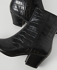 Black, croc-embossed ankle boots with block heels are arranged on a white surface. carousel Product Image 2