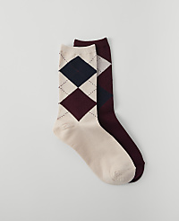Two argyle socks, one cream with navy and burgundy diamonds and the other burgundy with navy diamonds, are laid out against a plain white background. carousel Product Image 1