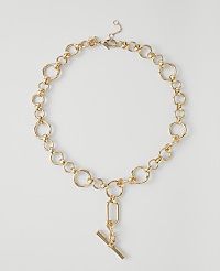 A gold chain necklace with a toggle clasp and pendant rests on a plain white background. carousel Product Image 1