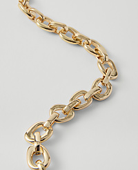A close-up of a gold chain with oval links curves across a plain white background. carousel Product Image 2