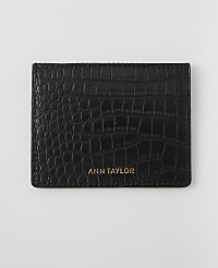 A black, crocodile-embossed cardholder with "ANN TAYLOR" in gold lettering rests on a plain white background. carousel Product Image 1