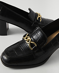 Black croc-embossed heeled loafers with gold chain accents are in the foreground, with another shoe slightly out of focus in the background. carousel Product Image 2