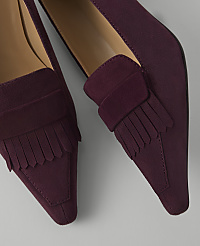 A pair of burgundy suede loafers with fringe detailing are displayed against a plain, light gray background. carousel Product Image 2
