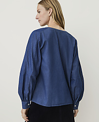 A woman in a blue denim blouse with voluminous sleeves stands against a plain white background. carousel Product Image 2