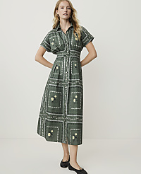 A woman in a green patterned midi dress stands against a plain white background. carousel Product Image 1
