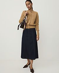 A woman in a camel cardigan and dark denim skirt stands against a plain white background. carousel Product Image 1