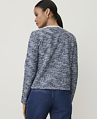 A woman in a textured blue jacket and dark jeans stands against a plain, light background. carousel Product Image 2