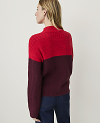 A woman in a two-toned red and burgundy sweater stands against a plain, light-colored background. carousel Product Image 2