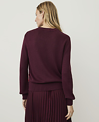 A woman in a burgundy sweater and pleated skirt stands against a plain, light-colored background. carousel Product Image 2