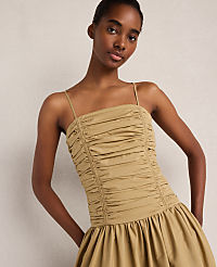 A woman in a ruched tan dress stands against a plain, light-colored background. carousel Product Image 2
