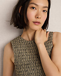 A young woman with short dark hair and a textured sleeveless top is posed against a neutral, textured background. carousel Product Image 4