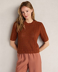 A young woman in a brown knit top and pink pants stands against a plain gray background. carousel Product Image 1