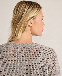 A woman with blonde hair is shown from the back, wearing a light gray, open-knit sweater against a neutral background. carousel Product Image 3