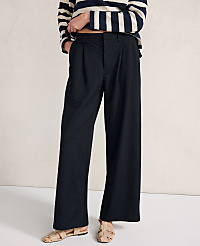 A person in dark, wide-leg pants and a striped shirt stands against a plain, light-colored background. carousel Product Image 1