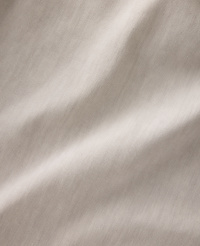 Soft, flowing folds of light brown fabric are illuminated by gentle light, creating subtle shadows and highlights across the textured surface. carousel Product Image 5