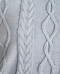 A close-up of a light blue cable-knit sweater with intricate braided patterns fills the frame. carousel Product Image 4