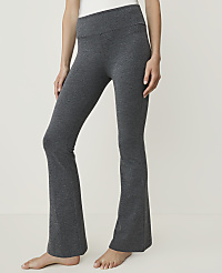 A person wearing charcoal grey flared yoga pants stands against a plain white background. carousel Product Image 1