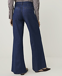 A person wearing dark wash flared jeans and a striped shirt stands against a plain white background. carousel Product Image 3