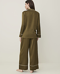 A woman in olive green satin pajamas stands against a plain, light-colored background. carousel Product Image 2