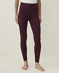 A person stands wearing burgundy leggings against a plain white background. carousel Product Image 1