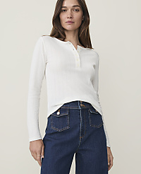 A woman in a white henley shirt and dark wash jeans stands against a plain, light background. carousel Product Image 1