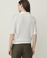A woman in a white knit polo shirt and olive green pants stands against a plain white background. carousel Product Image 2
