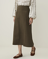 A woman in a patterned blouse and a long olive-green skirt stands against a plain, light-colored background. carousel Product Image 2