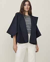A woman in a navy cape and striped shirt stands against a plain, light background. carousel Product Image 1