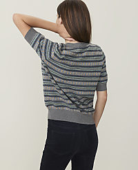 A woman in a striped sweater and dark pants stands against a plain, light-colored background. carousel Product Image 2