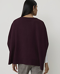 A woman wearing a burgundy poncho over a white shirt and plaid pants stands against a plain white background. carousel Product Image 2