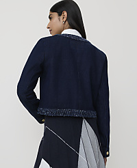 A woman in a denim jacket with a tweed trim stands against a plain white background. carousel Product Image 2