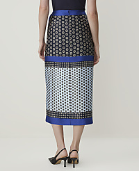 A woman in a patterned skirt stands against a plain, light-colored background. carousel Product Image 3