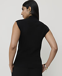 A woman in a black sleeveless turtleneck stands with her back to the camera, against a plain white background. carousel Product Image 2